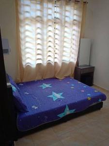 a bedroom with a blue bed with stars on it at Zarina's Budget Homestay in Tumpat