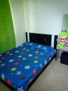 a bed with a blue comforter with stars on it at Zarina's Budget Homestay in Tumpat