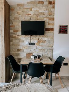 a dining room with a table and chairs and a tv at Zlatokosina zona Kopaonik Milmari NLux in Kopaonik