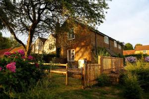 an old brick house with a fence and flowers at Admiral's Cottage in Bridport +7 photos