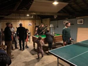 a group of people standing around a pool table at Admiral's Cottage in Bridport
