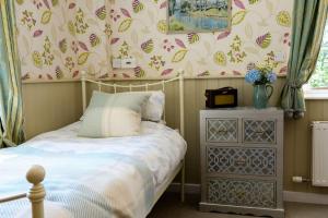 a small bedroom with a bed and a dresser at Admiral's Cottage in Bridport