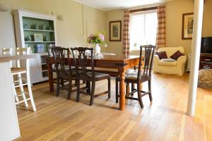 a dining room with a wooden table and chairs at Admiral's Cottage in Bridport