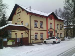 シュムペルクにあるHostinec Peterkaの雪に止められた白い車が停まった建物