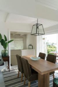 a dining room with a wooden table and chairs at Beach House in Cape Town