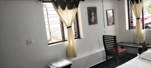 a bedroom with a bed and a chair and a window at Annie's Villa in Kovalam