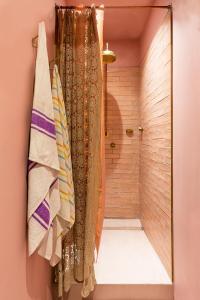 a bathroom with a walk in shower with a shower curtain at Hotel Lola in Cape Town
