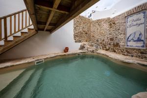a swimming pool in a house with a stone wall at Villa Galega in Santa Cruz