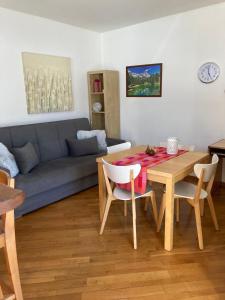 sala de estar con mesa y sofá en La maison de Linanna, en Aymavilles
