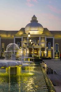 un gran edificio con una fuente frente a él en The Grand Nirvana Hotel, en Bareilly