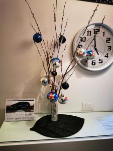 a vase with christmas ornaments on a table with a clock at Apartment Jovana Krunska in Belgrade