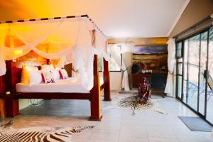 a bedroom with a bed with a canopy at Omukuyu Wildlife Lodge in Otavi +36 photos