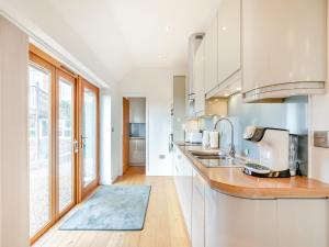 a kitchen with white cabinets and a large window at Larks Nest in Wortham