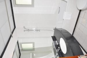 a white bathroom with a sink and a toilet at Akas-Inn Hotel Apartment in Dubai