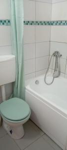 a white bathroom with a toilet and a bath tub at Piata Muzeului 1 in Cluj-Napoca