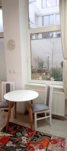 a white table and chairs in a room with a window at Piata Muzeului 1 in Cluj-Napoca