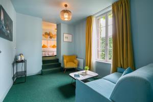 ein Wohnzimmer mit Sofa und Fenster in der Unterkunft Le Central Boutique Hôtel in Beaune