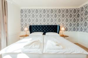 a bedroom with a large bed with two lamps at Vila Cornelia in Banská Štiavnica