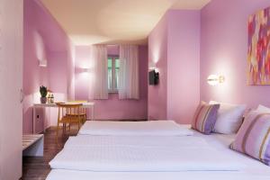 2 camas en una habitación con paredes moradas en Hotel Kunterbunt - by homekeepers, en Würzburg