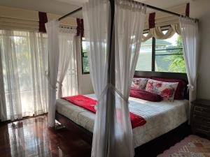 1 dormitorio con cama con dosel y ventanas en HomeSweetHome en Hang Dong