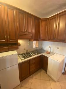 a kitchen with wooden cabinets and a white refrigerator at Nevegal 200mt dalle piste,posto auto coperto,wifi,camino. in Nevegal