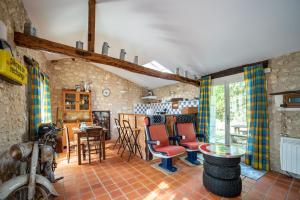 ein Wohnzimmer mit roten Stühlen und einem Tisch in der Unterkunft Gîte de La Vieille Bécane in La Gonterie-Boulouneix