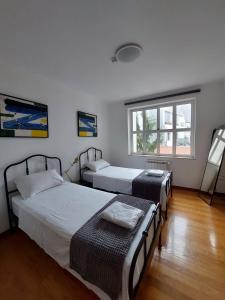 um quarto com três camas e uma janela em Guest House Sir Manuel - Unidade Senhora A Branca em Braga