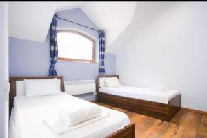 a small room with two beds and a window at Dilijan Dream House! 3 Bedroom Amazing Villa in National Park! in Dilijan