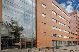 een groot bakstenen gebouw met glazen ramen bij Boutique Apartments Amsterdam in Amsterdam