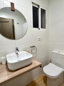 y baño con lavabo, aseo y espejo. en Apartamentos Palangres, en Torrevieja