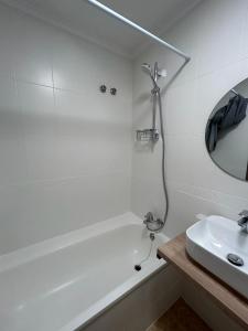 y baño con bañera blanca y lavamanos. en Apartamentos Palangres, en Torrevieja