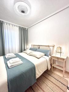 1 dormitorio con 1 cama grande con manta azul en Apartamentos Palangres, en Torrevieja