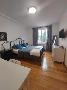 a bedroom with a bed with blue pillows and a table at Guest House Sir Manuel - Unidade Senhora A Branca in Braga