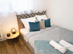 een slaapkamer met een groot bed met blauwe kussens bij Apartament Skandynawski in Mielec