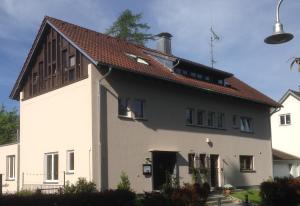 une maison blanche avec un toit rouge dans l'établissement Gunkel Ferienwohnungen am See - Konstanz - Musikerviertel, à Constance