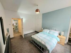 una camera con un letto con una parete blu di Granite Getaways - The Terrace Below ad Aberdeen