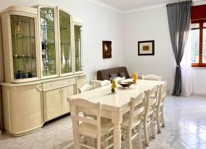 a dining room with a white table and chairs at Sorrento's Carme family big appartament in Sorrento