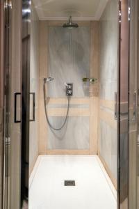 La salle de bains est pourvue d'une douche et d'une porte en verre. dans l'établissement Relais & Châteaux Hotel Orfila, à Madrid
