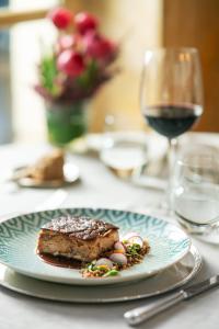a plate with a piece of cake and a glass of wine at Relais & Châteaux Hotel Orfila in Madrid
