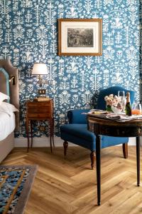 a room with a table and a blue and white wallpaper at Relais & Châteaux Hotel Orfila in Madrid