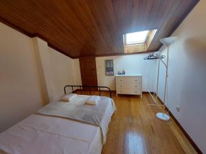 - une chambre avec un lit et un plafond en bois dans l'établissement Guest House Sir Manuel - Unidade Senhora A Branca, à Braga