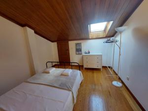 a bedroom with a bed with a wooden ceiling at Guest House Sir Manuel - Unidade Senhora A Branca in Braga