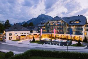 un gran edificio con coches estacionados frente a él en Hotel Friesacher en Anif