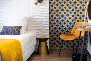 ロワイヤンにあるle Foncillionのベッドルーム1室(黄色い毛布と椅子付きのベッド1台付)