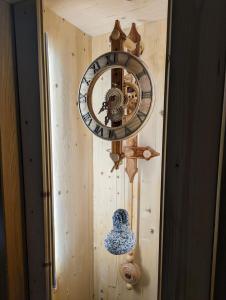 un orologio sul lato di una parete di legno di Hotel Cova a Pellizzano