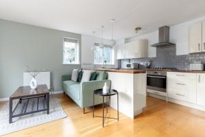 倫敦的住宿－The Camberwell Apartment，厨房以及带沙发和桌子的客厅。