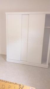 a white cupboard in a room with a rug at Appartamento con piscina Santa Maria area in Hurghada