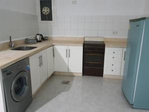 a kitchen with a sink and a dishwasher at Appartamento con piscina Santa Maria area in Hurghada