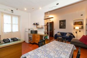 a kitchen and a living room with a table and a couch at Mercato Centrale Roomy Apartment in Turin