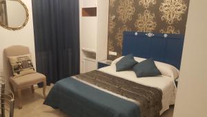 ein Schlafzimmer mit einem blauen Bett und einem Stuhl in der Unterkunft hospedaje barahona21 in León